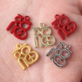 Five colorful alloy Fu character charms for DIY jewelry making displayed on a palm - Random Mix