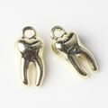 Vista macro dettagliata di due ciondoli a forma di dente in lega d'oro per gioielli - Oro