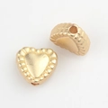 Macro detail of matte gold heart beads with serrated edges for DIY jewelry making - Matte Gold