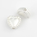 Macro detail of silver heart-shaped alloy beads with embossed texture for DIY jewelry making - Silver White