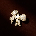Elegante spilla a fiocco con cristalli scintillanti e perla d'acqua dolce su base oro - Stile Elettroforesi Oro 18K