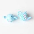 Close-up of light blue miniature teapots with floral patterns for DIY jewelry making - Blue