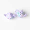 Macro view of mini purple teapot charms with embossed floral pattern for DIY jewelry - Purple