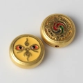 Detailansicht goldener Legierungsanhänger mit buntem Emaille für DIY-Schmuckherstellung - Gelber Hintergrund Zwei Augen