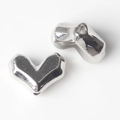 Close-up of polished silver heart-shaped alloy beads for DIY jewelry making - Silver