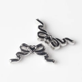 Détail macro de perles nœuds en argent avec cœur en émail noir pour bijoux DIY - Argent