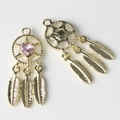 Macro detail of golden dreamcatcher pendant with pink heart gemstone and metal feathers - Gold Base Pink