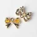 Detalle de colgantes de lazo en aleación con piedras de circón amarillo y oro - Base de Oro Amarillo