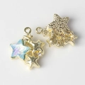 Detailed macro view of gold star-shaped pendants with iridescent resin and zircon inlay - Gold Base Blue