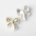 Macro detail of pearlescent bow beads with golden metal frame and pearl centerpiece - Platinum