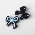 Macro shot of resin bow charms with imitation pearl center for DIY jewelry making - Black Blue