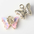Detailed view of alloy butterfly charms with iridescent purple zircon and gold metal backing - Gold Base Pink