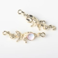 Detalle de conectores de mariposa dorada con gemas púrpuras para creación de joyería - Base de Oro Blanco