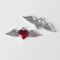 Detail of silver wing heart pendant with red enamel inlay and star embossed backing - Silver Base Red