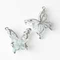 Macro shot of silver-edged butterfly resin pendants for DIY necklace jewelry making - Silver Base Blue