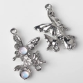 Macro detail of alloy butterfly pendants with silver finish and synthetic opal stones - Silver Pink