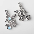 Macro shot of silver fairy pendants with light blue stones and double metal rings - Silver Base Blue