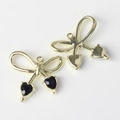 Vista macro de colgantes de lazo dorado con circonitas negras en forma de corazón - Base De Oro Diamante De Imitación Negro