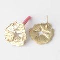 Vue détaillée des boucles d'oreilles pétales dorées avec texture martelée et étoile - Style Rond Irrégulier Feuille de Lotus Étoile Évidée / Or