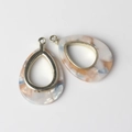 Close-up of teardrop marble resin pendants with gold metal frames for DIY jewelry - White