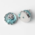 Macro shot of light blue resin lotus pod pendant with silver-tone filigree metal base - Silver Base Blue