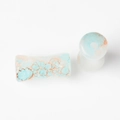 Macro view of saddle ear plugs with blue and orange marble texture on white background - Dunhuang Style