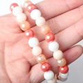 Close-up of 8mm candy color glass round beads showing smooth iridescent texture on hand - Style 5