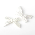 Detail of matte silver alloy bow charms with intricate diamond pattern for DIY jewelry - Silver White