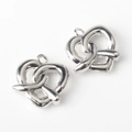 Close-up of a pair of silver-plated twisted pretzel charms for DIY jewelry making - Silver
