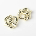 Close-up of golden alloy pretzel-shaped pendants for DIY necklaces and bracelets - Gold
