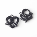 Close-up of black glossy heart-shaped pretzel pendants for DIY jewelry crafting - Black