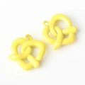 Detail of yellow pretzel-shaped alloy pendant charms with smooth matte enamel finish - Yellow