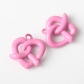 Primer plano de colgantes de pretzel rosa esmaltado para creación de joyas y pulseras DIY - Rosa rojo
