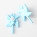 Close-up of light blue windmill charms with pearl inlay for DIY jewelry making - Blue