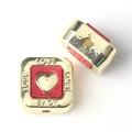 Close-up of square gold alloy beads with red resin hearts and LOVE engraving for DIY jewelry - Red