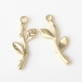 Makro-Detail goldener Metall-Zweiganhänger mit Blattstruktur für DIY-Schmuckherstellung - Mattgold