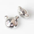 Macro view of panda-shaped silver alloy beads with pink enamel detailing and central hole - Silver