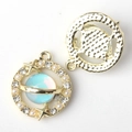 Macro view of gold alloy planet charm with iridescent blue stone and star details - Gold Base Blue