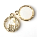 Detailed macro view of golden castle coin pendants with intricate white enamel inlay - Gold