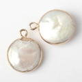 Dettaglio di pendenti in perle barocche tonde con bordo dorato e lucentezza naturale - Oro