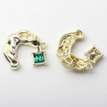 Detail of C-shaped golden pendant with emerald zircon and fluid lava texture - Green with Gold Base