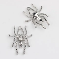 Dettaglio macro di pendenti a ragno in lega con finitura argento lucido e intarsio di strass - Galvanico Argento con Strass Trasparente / Argento / Zirconia Bianca