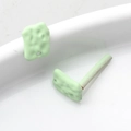 Macro shot of mint green geometric earrings with matte biscuit texture and silver pins - Light Green