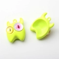 Detailansicht der Vorder- und Rückseite des grünen kleinen Monsteranhängers für Schmuck - Neongelb