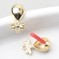 Macro detail van goudkleurige hanger met kristallen strik en rode naald beschermkap - Strass Goud