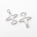 Detalle macro de dijes de avión plateados con diseño hueco para creación de joyas - Plateado