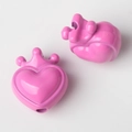 Close-up van roze hartvormige bedels met kroon en glanzende afwerking voor DIY-sieraden - Rozerood