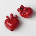 Macro-opname van glanzende rode hart-kroonbedels voor DIY-sieraden maken - Rood