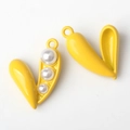 Macro shot of two yellow pea pod alloy charms with white pearls and hanging loops - Yellow White Pearl