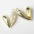 Macro shot of golden pea pod pendant with white faux pearls and detailed hollow back - Gold White Pearl